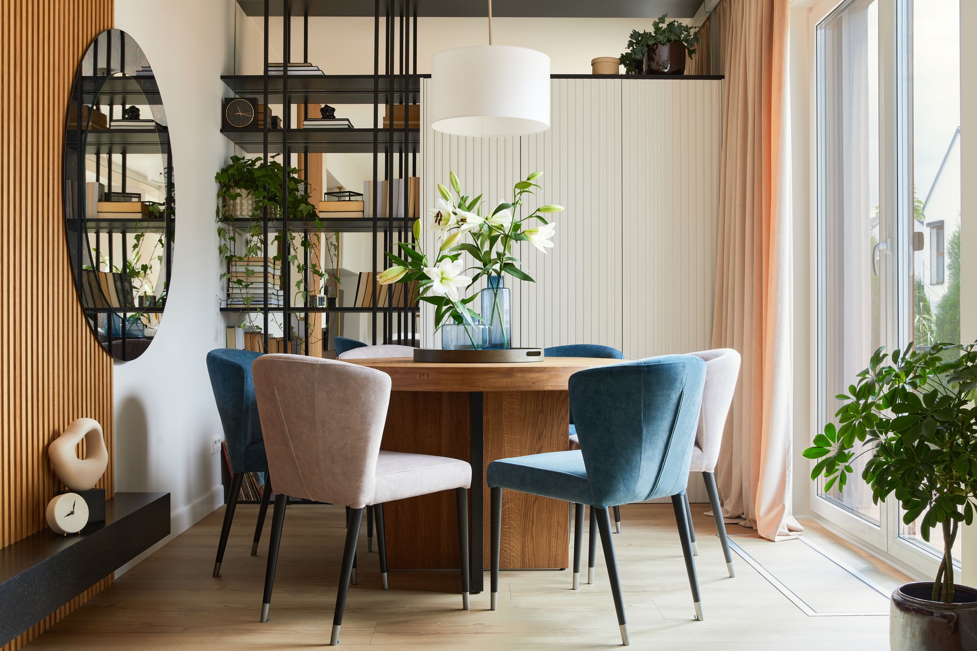 Composition élégante d’un design intérieur élégant de la salle à manger avec des fauteuils en velours, une table en bois arrondie design et de beaux accessoires personnels. Inspiration de design d’intérieur glamour. Modèle.