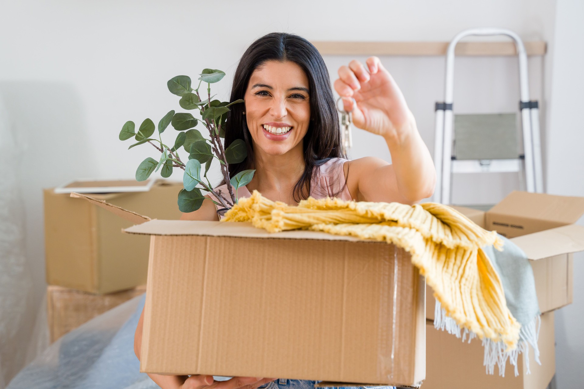 femme tenant des clés et déballant la décoration intérieure dans un nouvel appartement